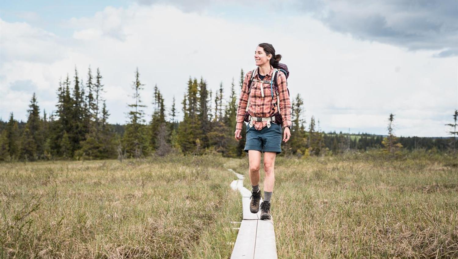 Person walking on a path through open landscape