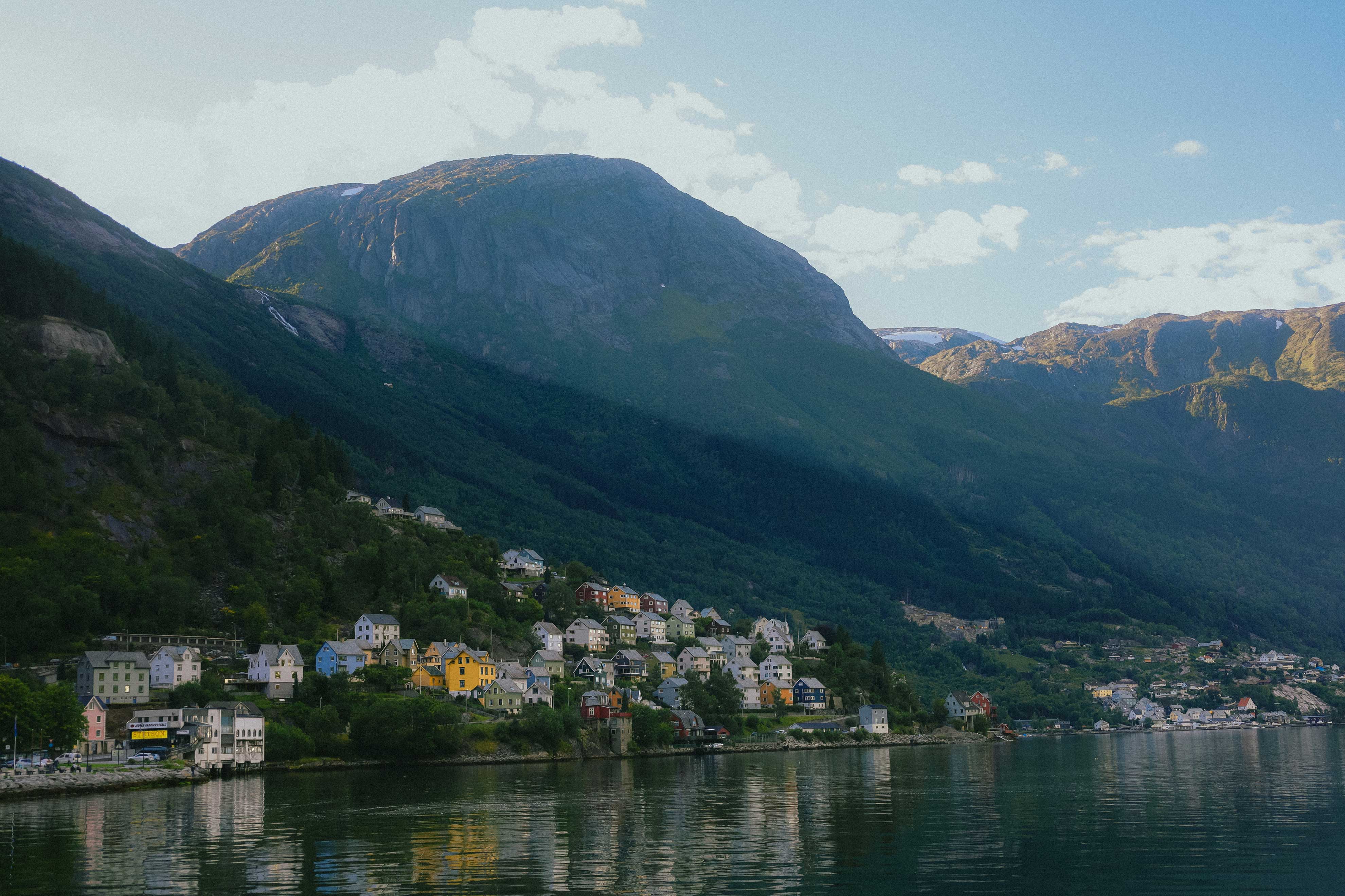 Evening light over Odda with colorful houses scattered along the steep hillsides.