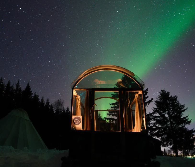 glasshytta med nordlys over