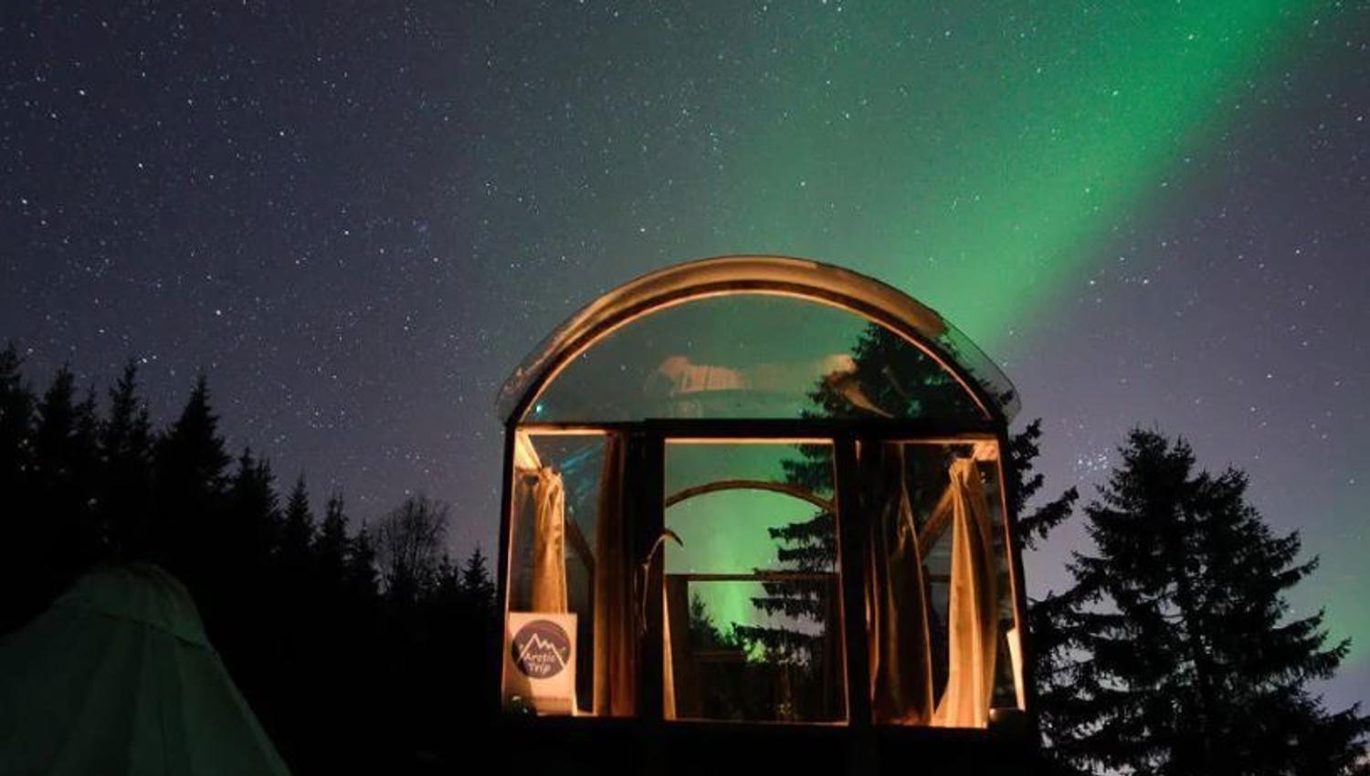 glasshytta med nordlys over