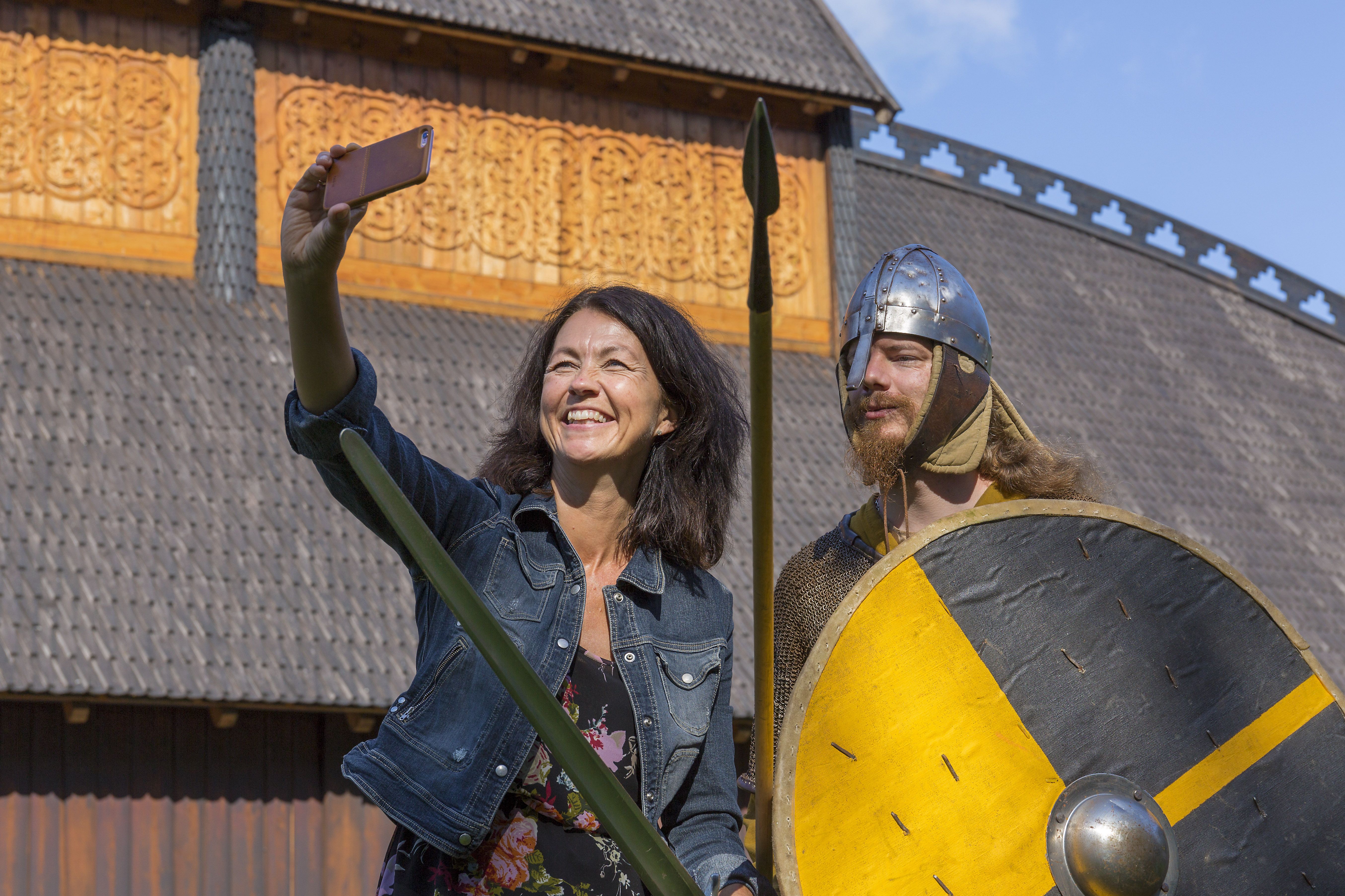 Woman takes selfie with man dressed in Viking costume