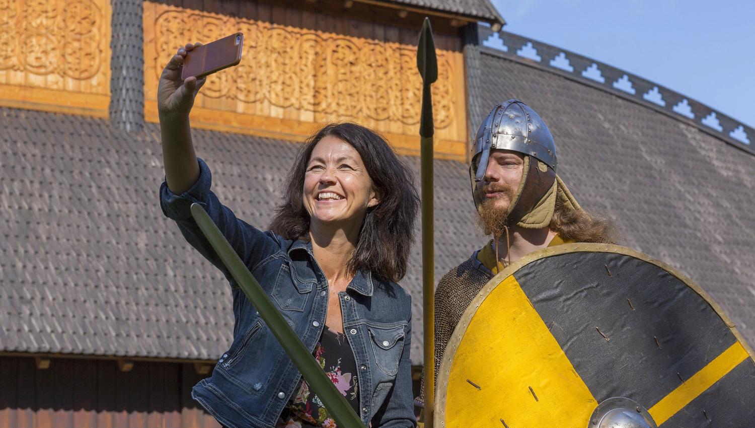 Woman takes selfie with man dressed in Viking costume