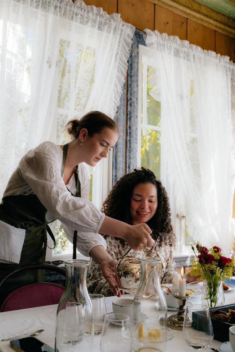 A server pours from a silver pot at the breakfast table in the dining room of Utne Hotel, Hardanger.