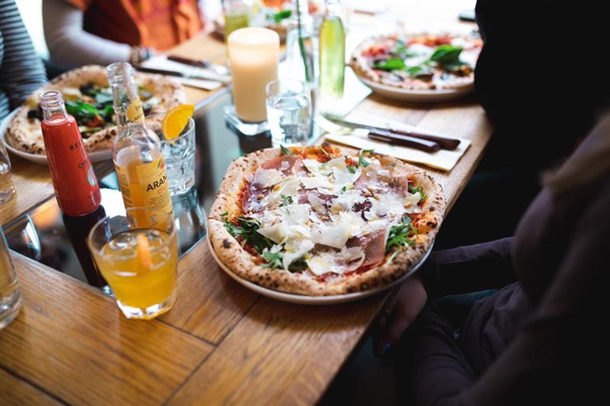 Pizzer og drikke på et spisebord