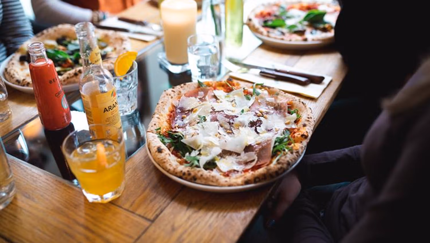 Pizzer og drikke på et spisebord
