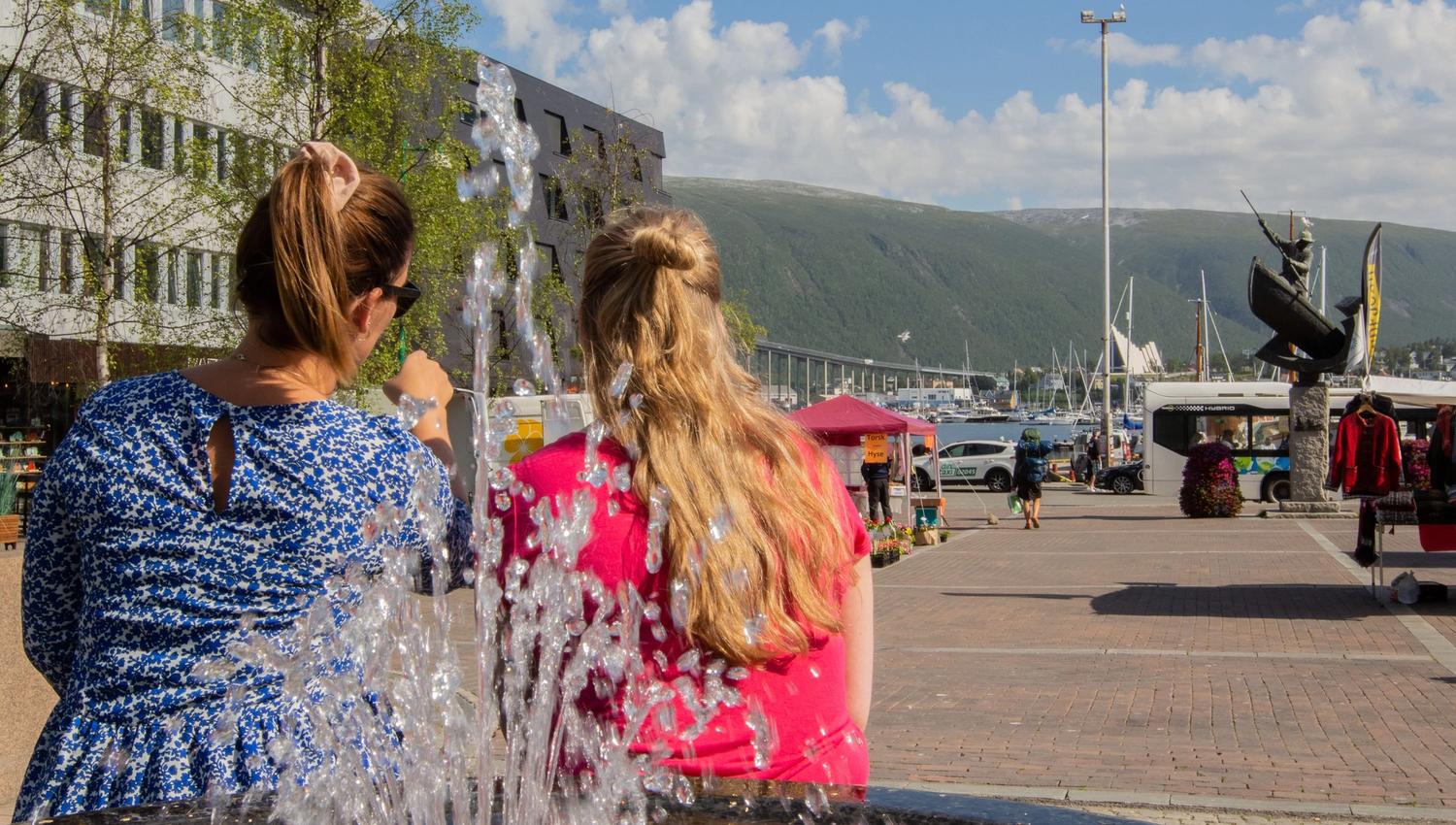 Friends sitting by the fountain at the main square