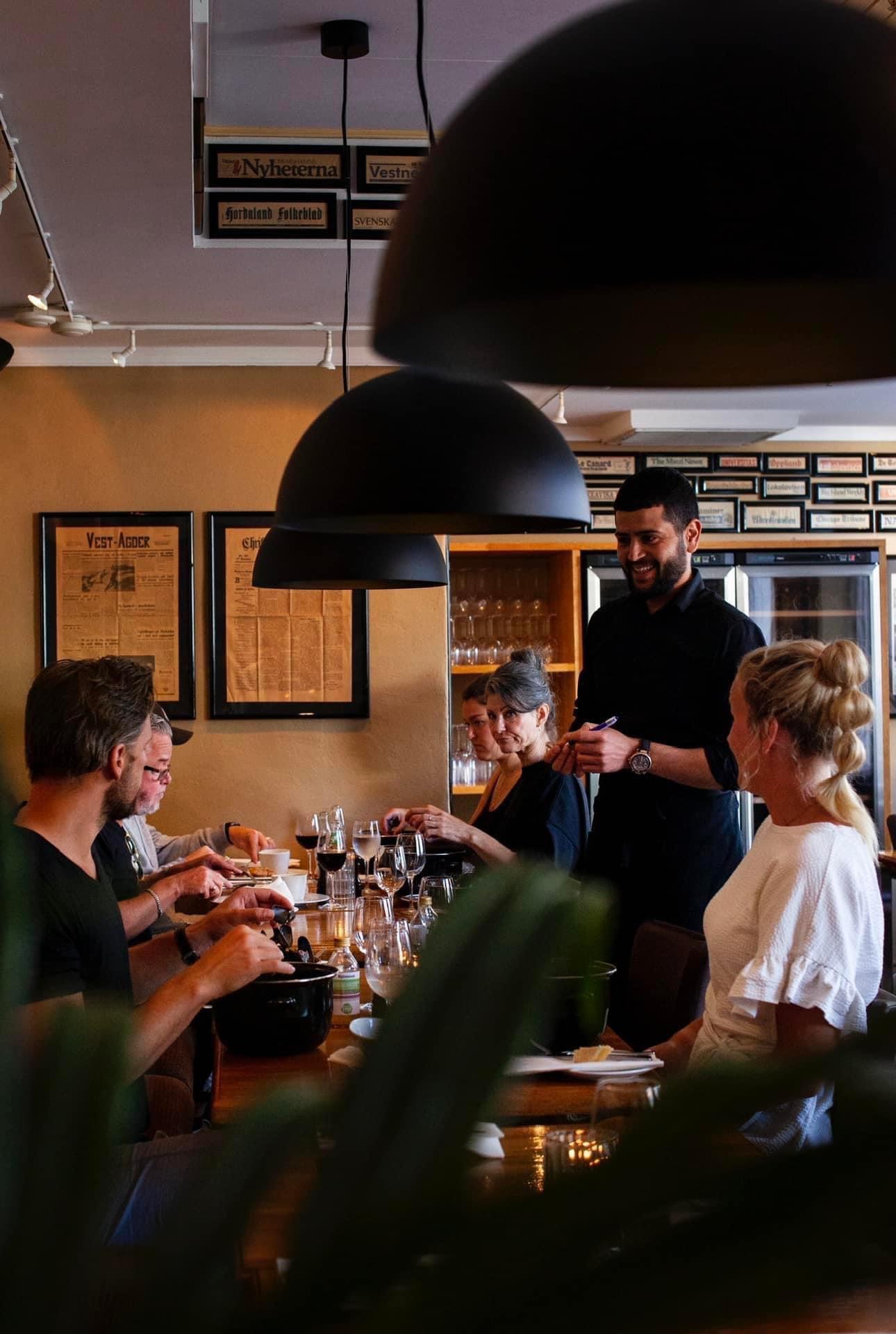 Waiter serving smiling guests.