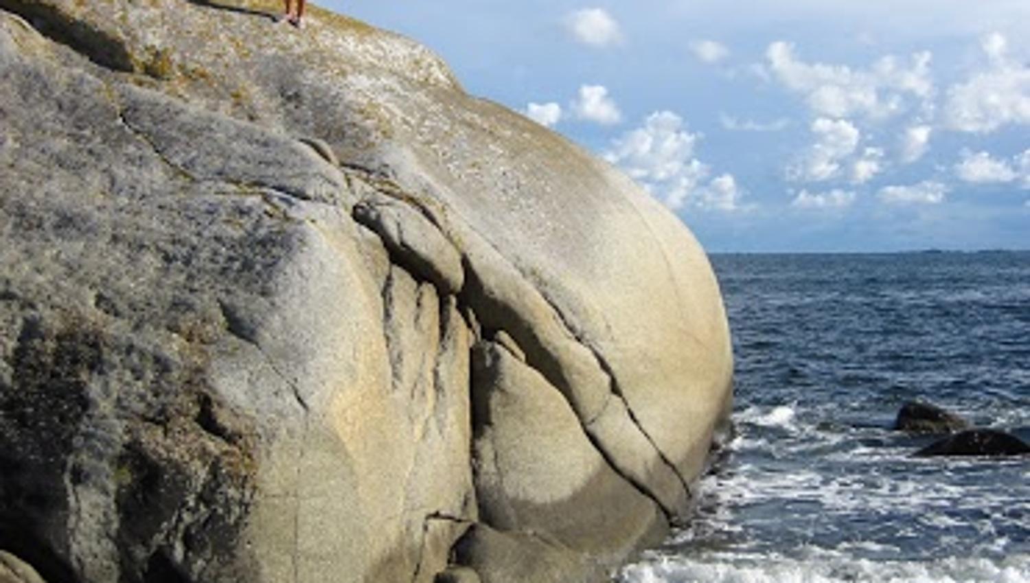 Person on mountain by the sea