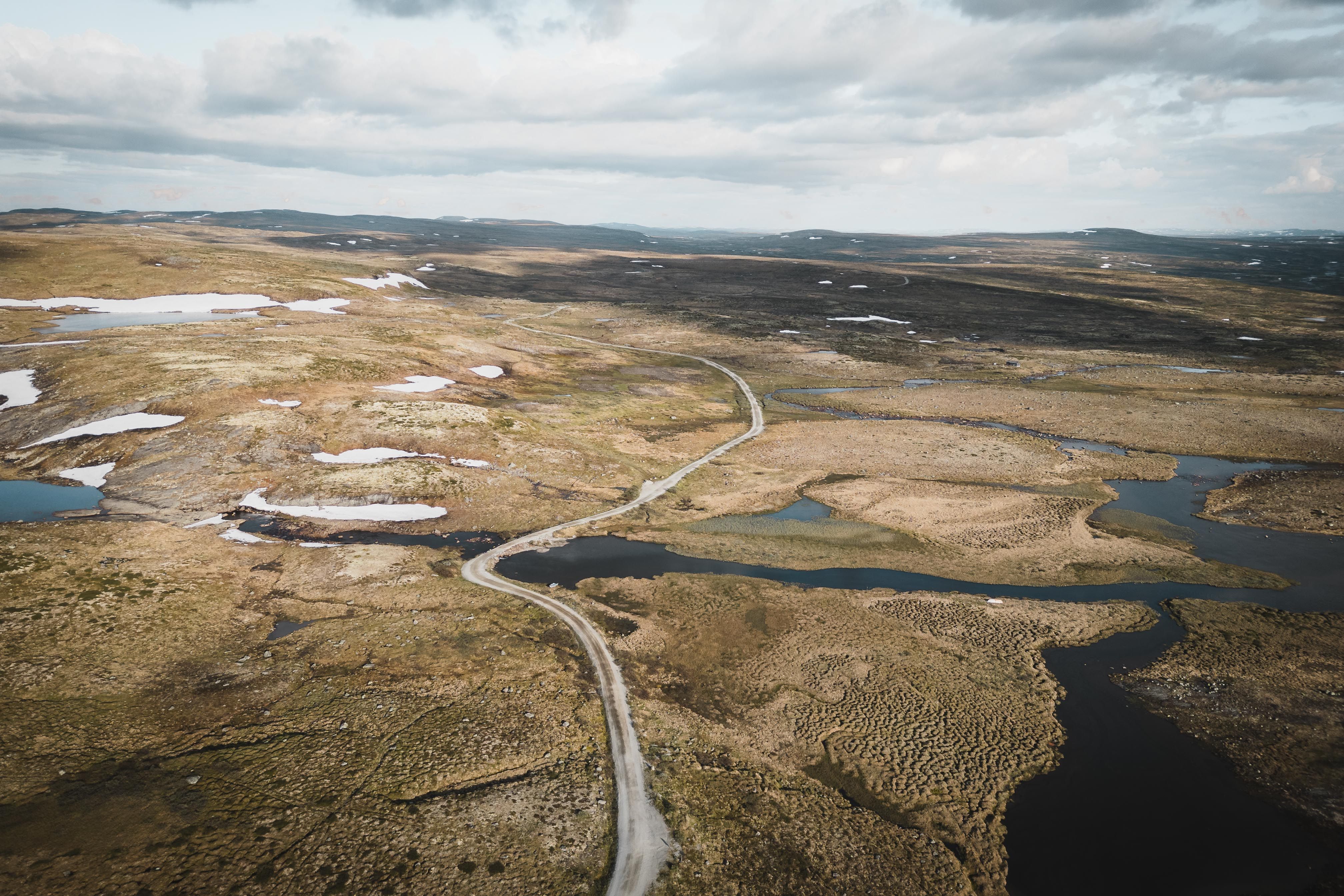 A drone photo of the Tinnhølvegen road, witha cloudy sky in the background.
