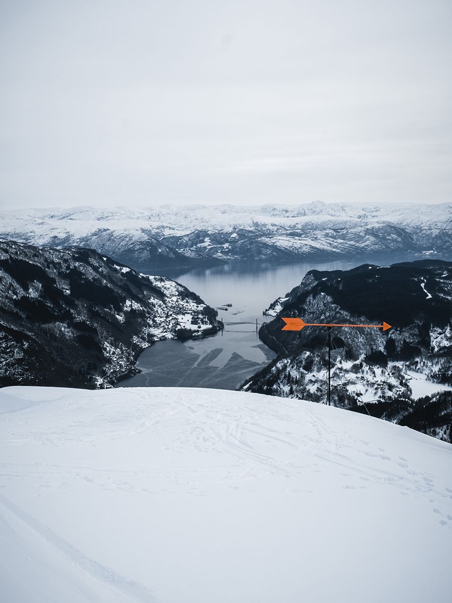View of the Hardangerfjord from snowy mountain slopes.