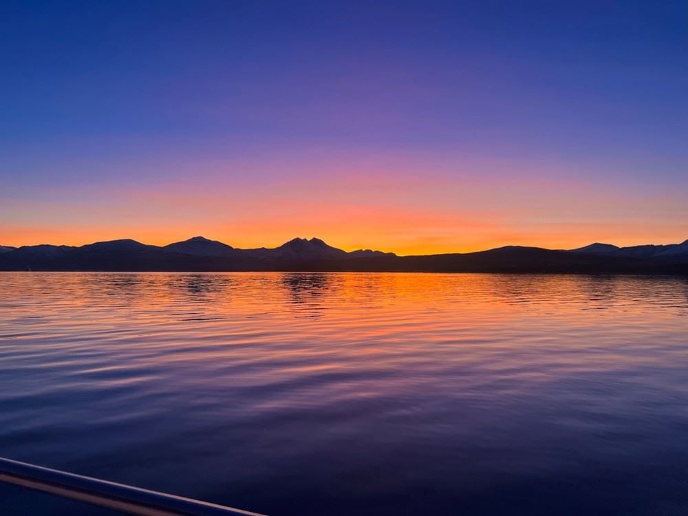 Colourful sunset with the sea and mountains in the background
