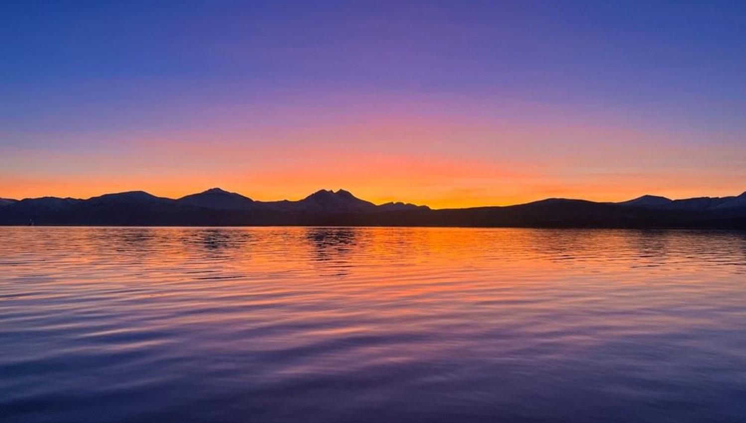 Colourful sunset with the sea and mountains in the background