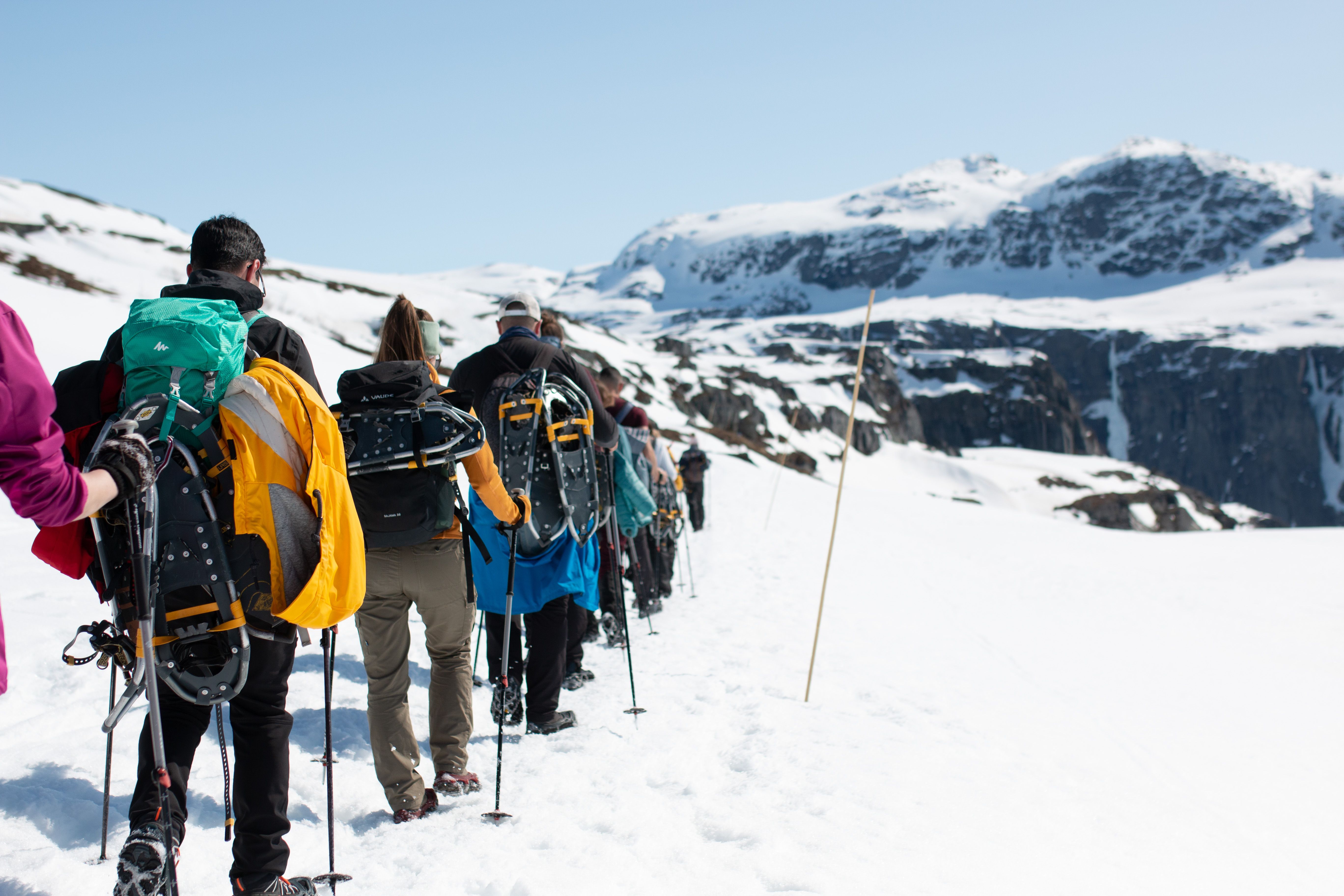 A group of people on a Trolltunga winter snowshoe hike. 