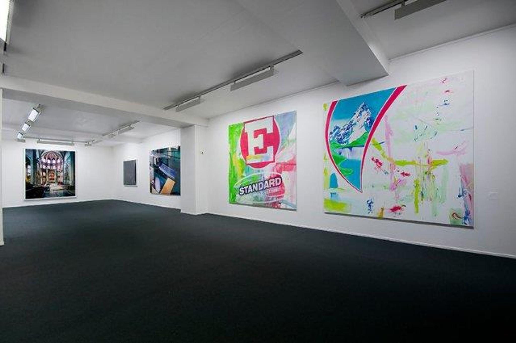 Various large pop art paintings hanging on white walls.