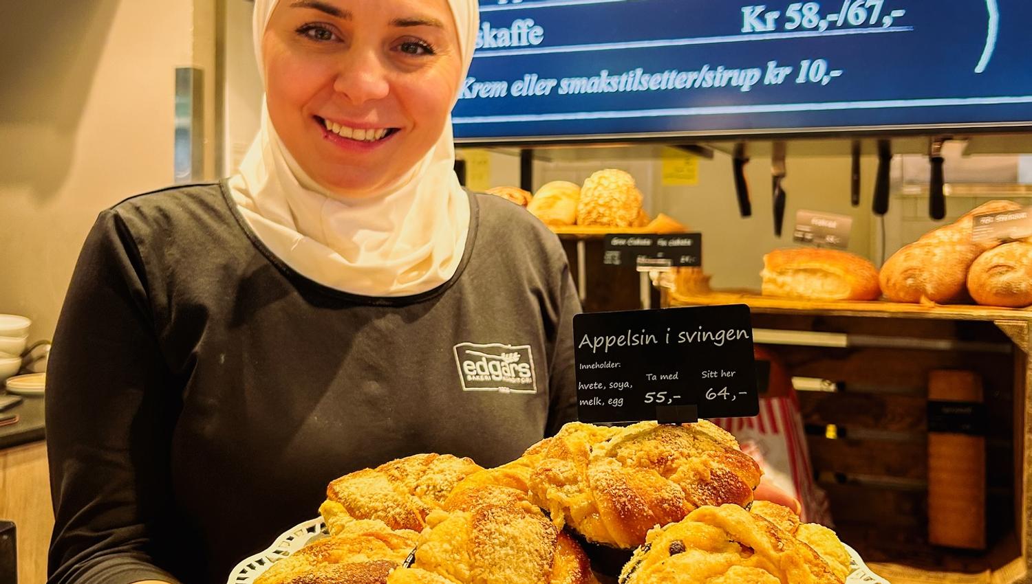 Smilende ansatt fra Edgars viser frem bakverk