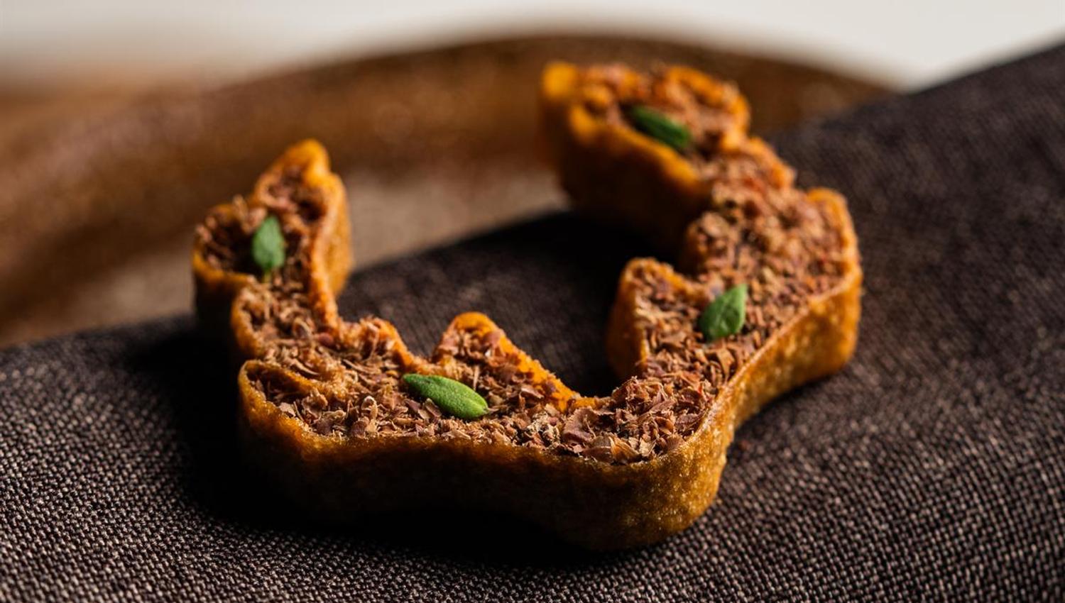 Crispy snack served on a dark cloth.