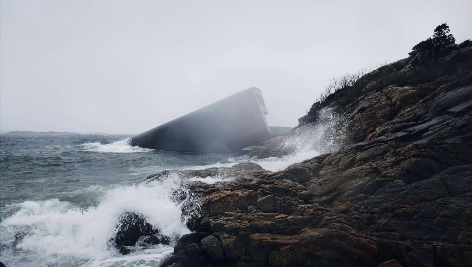 The restaurant in foggy weather with waves crashing against the rocky shore