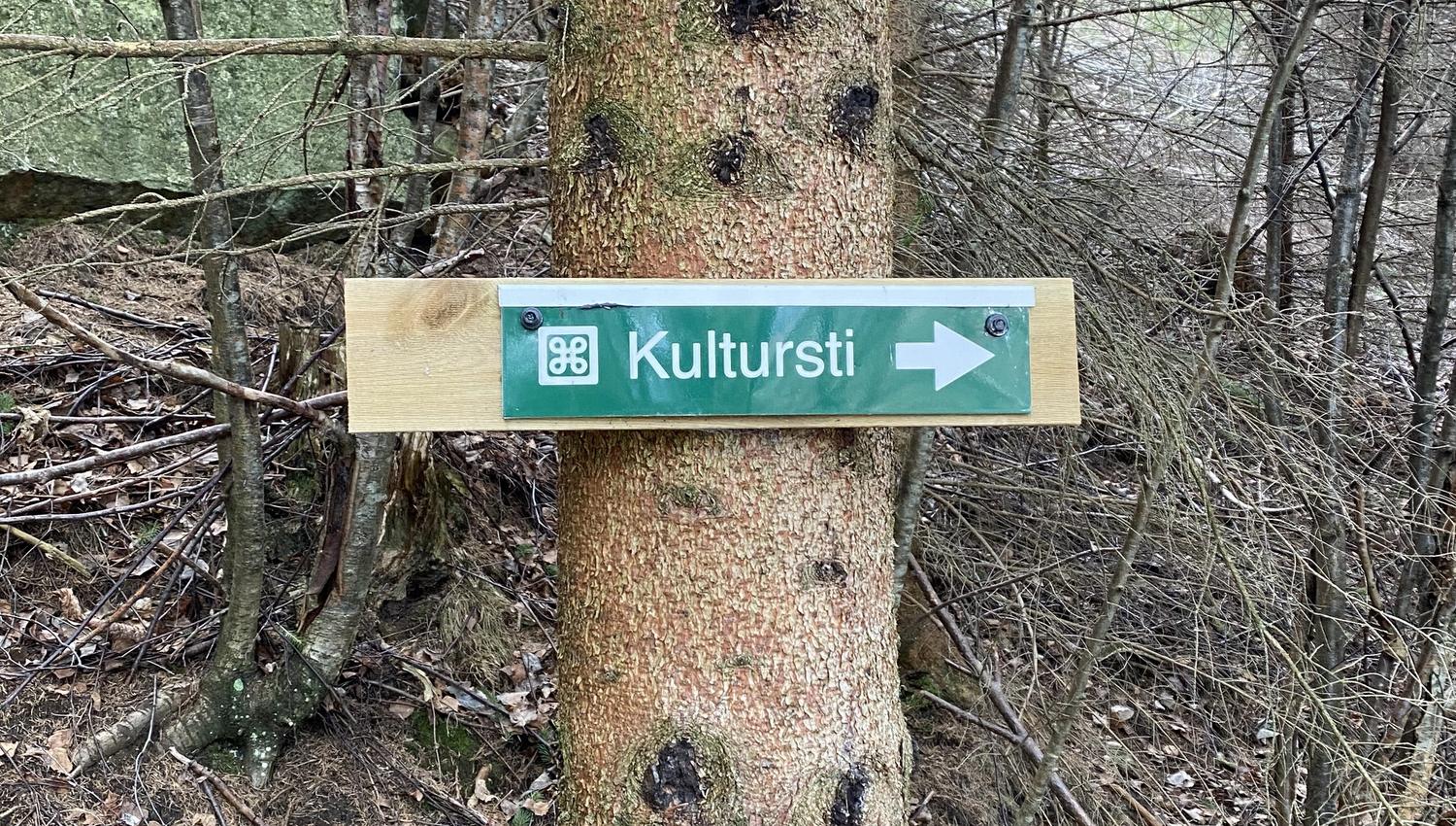 Wooden sign pointing the way to the Hjøllo–Mannsåker cultural trail in Hardanger.