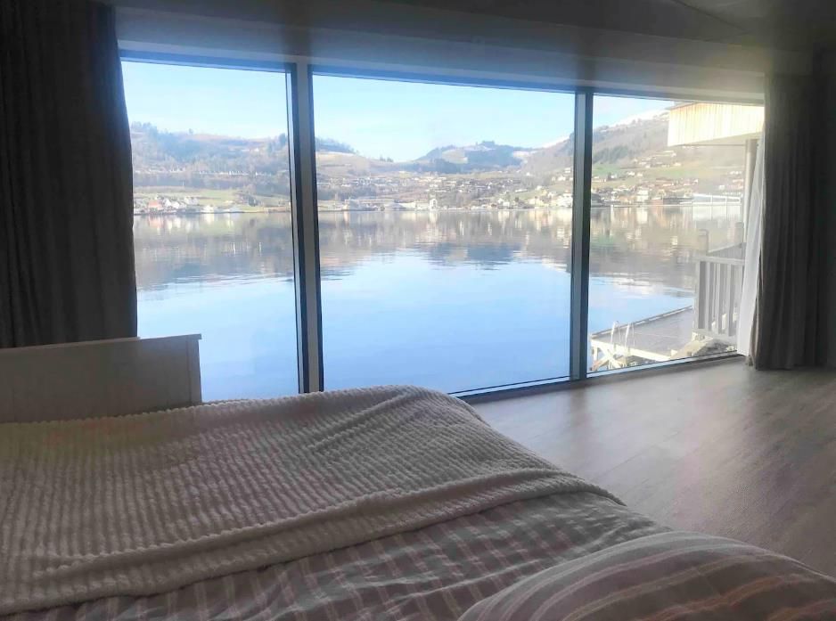 Dreamlike view of the Hardangerfjord from an elegant bedroom with large panoramic windows.