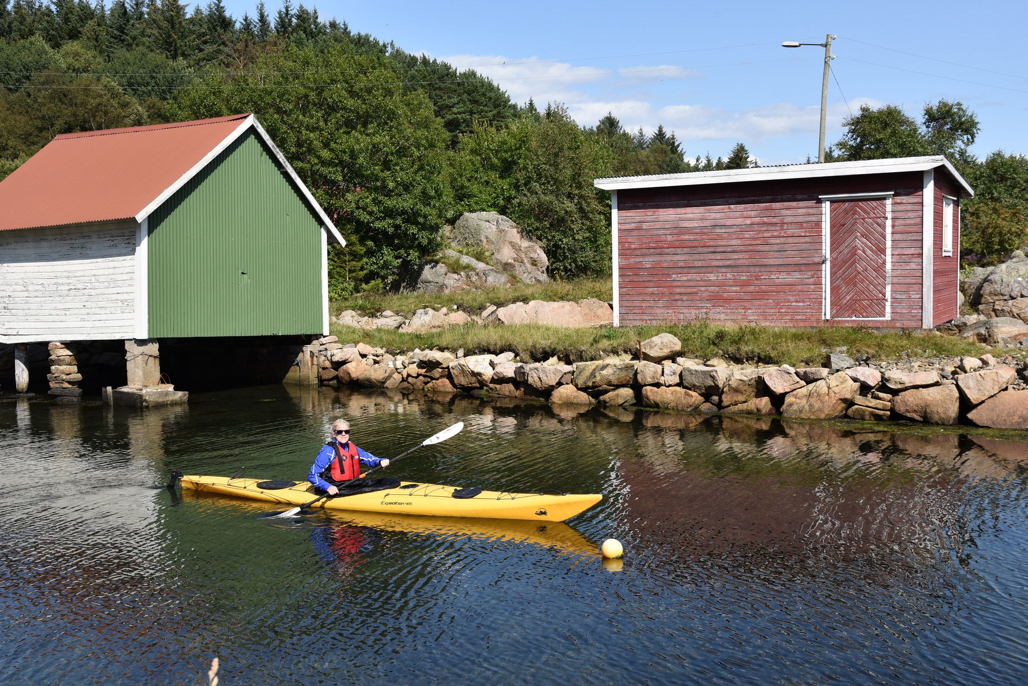Kvinne i gul kajakk som padler