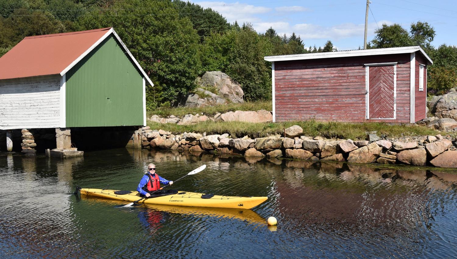 Kvinne i gul kajakk som padler