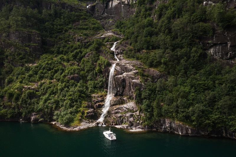 Pilagutt in front of a powerful waterfall in the Hardangerfjord – a magical place for nature experiences on the fjord.