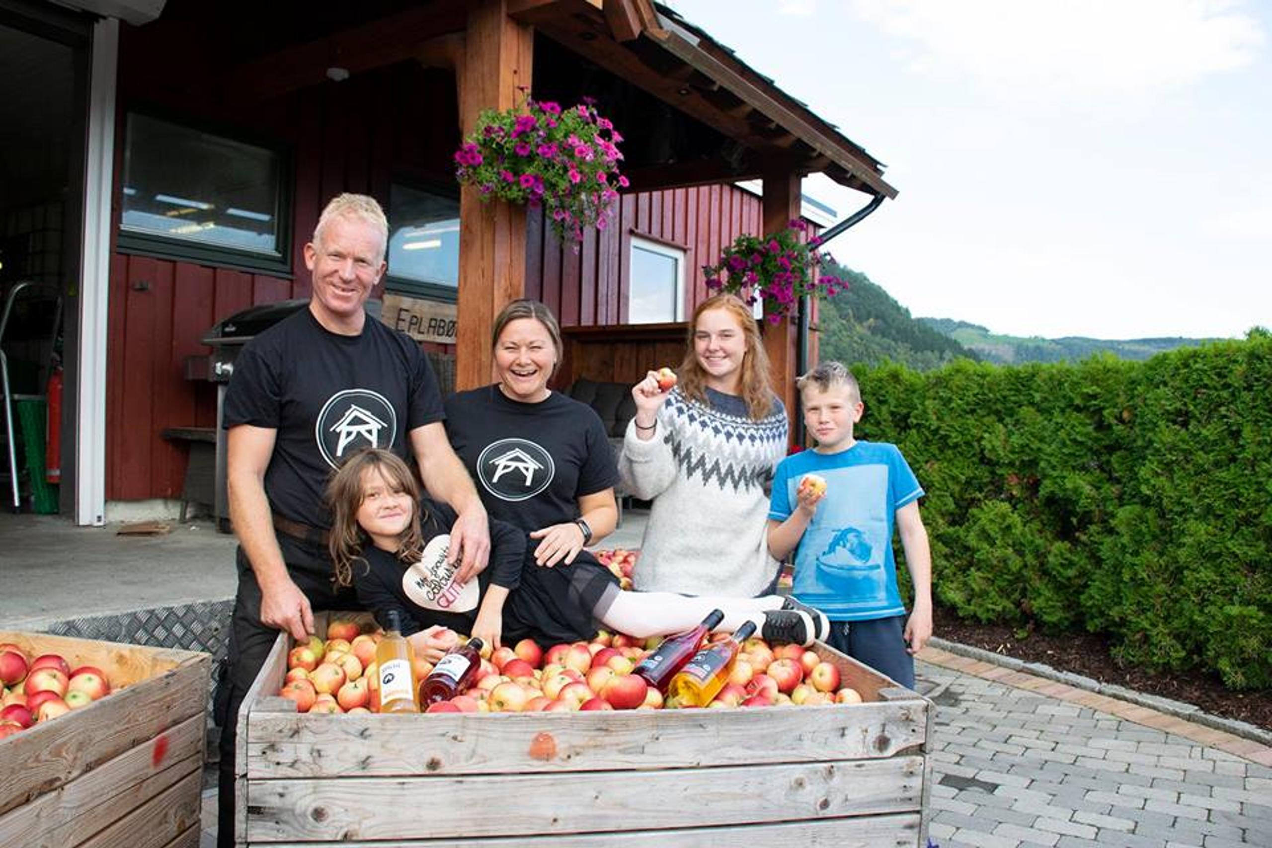 Ein familie nyt haustinga av ferske eple på Spildegarden i Hardanger. Opplev ekte norsk frukttradisjon i hjartet av fjordlandskapet!