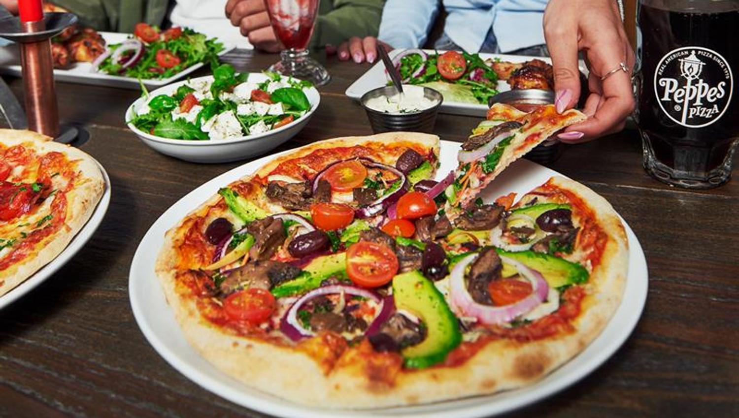 Two people eating pizza.