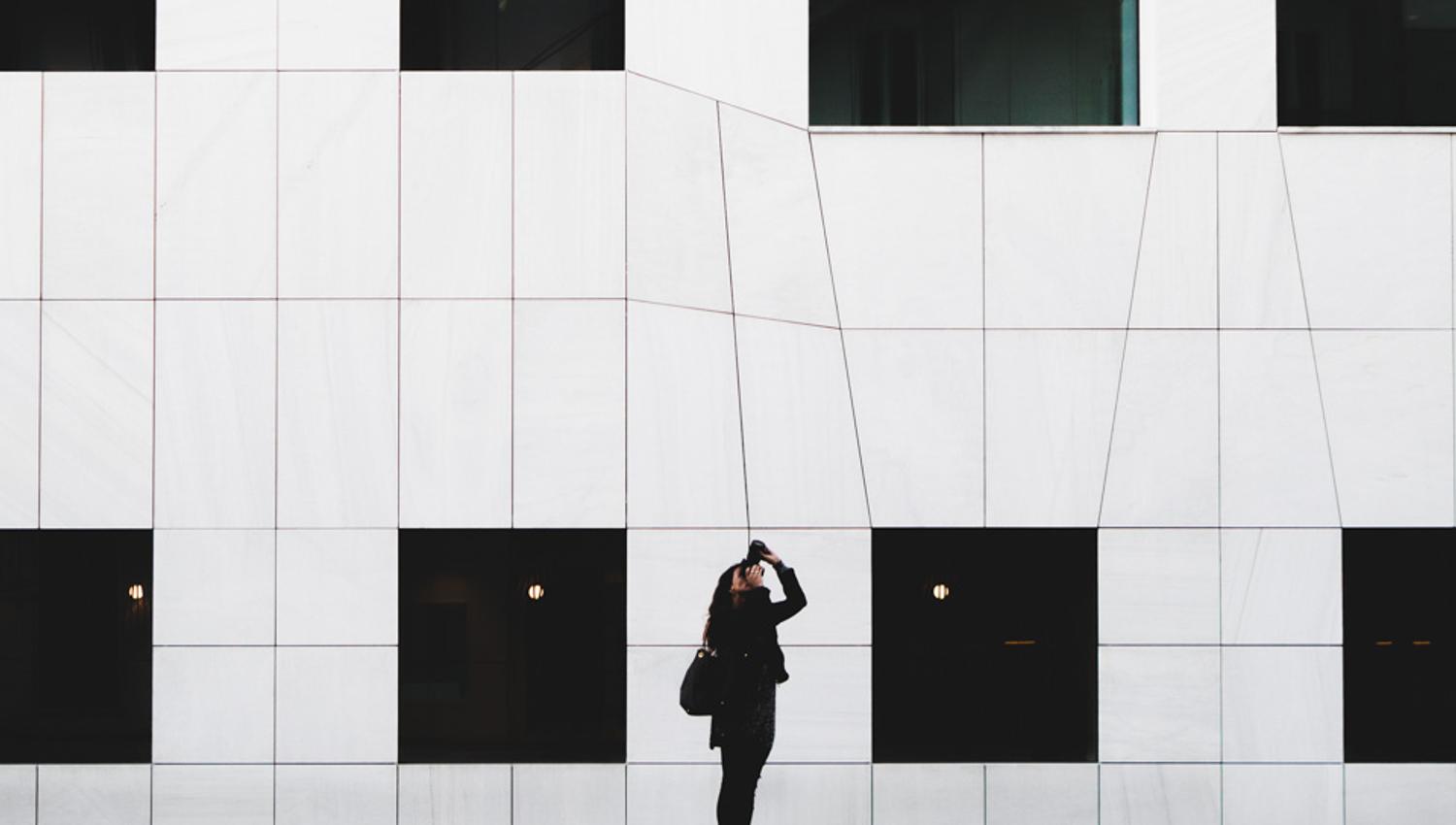 White building with person taking a picture.