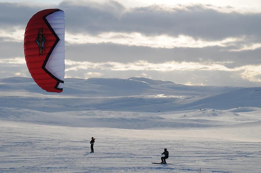 A snowkiter with a red kite.