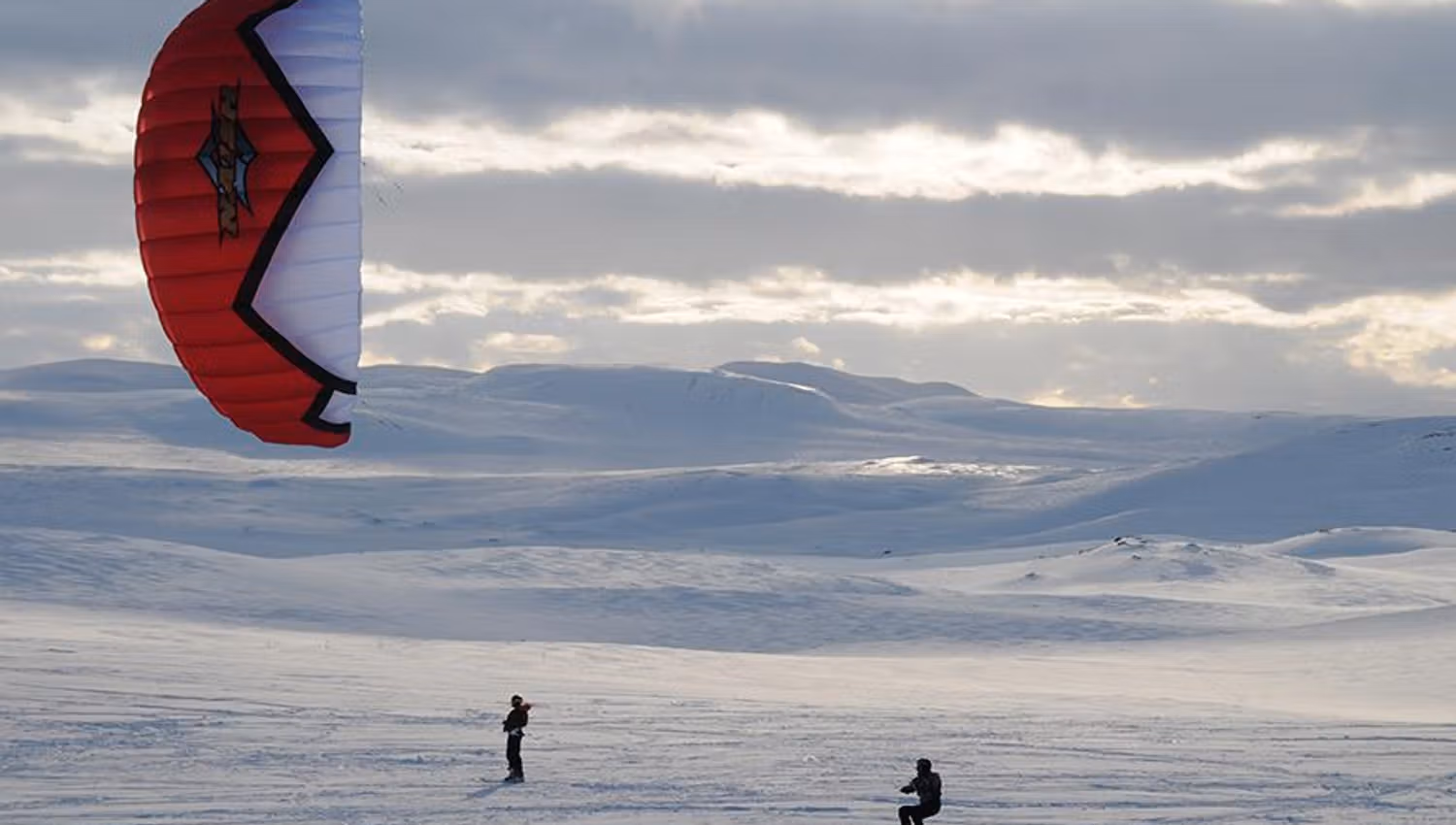 A snowkiter with a red kite.