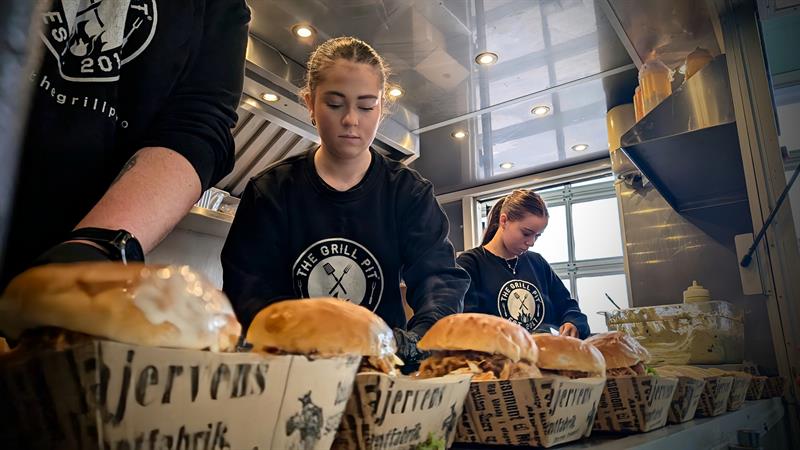 Ansatte på kjøkkenet hos The Grill Pit tilbereder burgere.