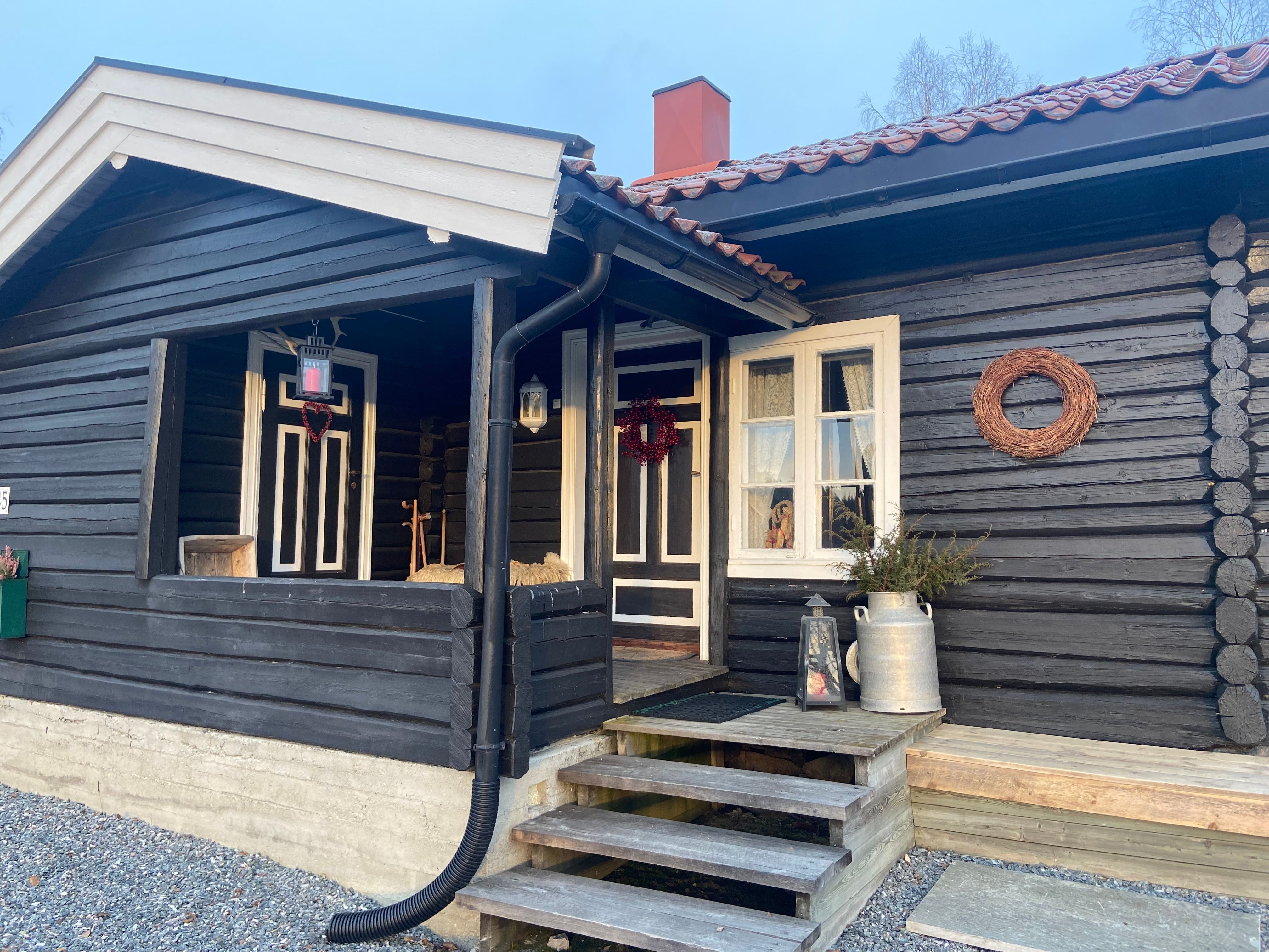 svart hytte med inngangsparti