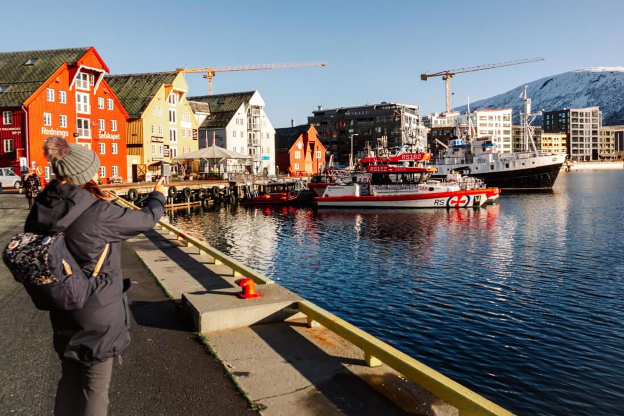 A lady photographing from the harbour in Tromsø