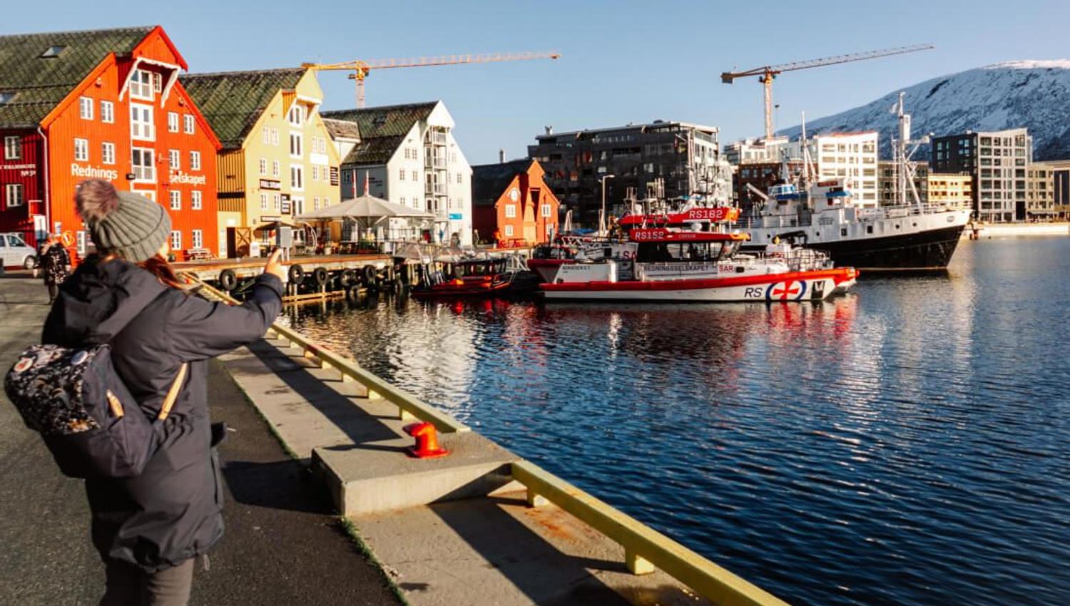 A lady photographing from the harbour in Tromsø