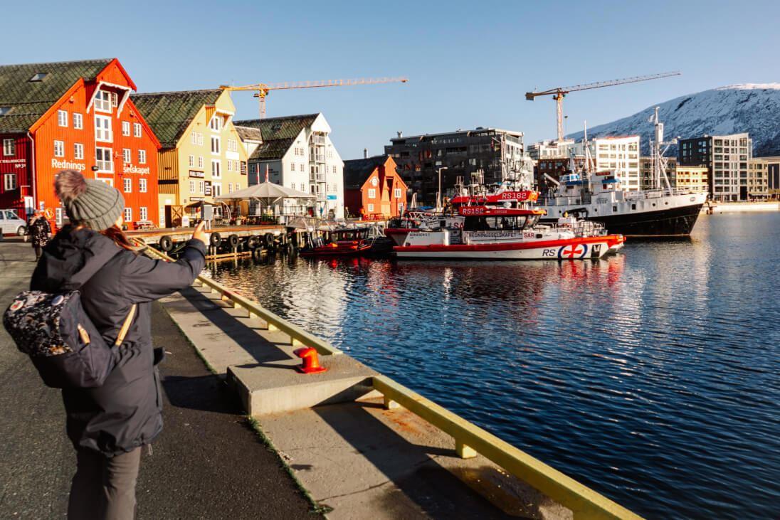 A lady photographing from the harbour in Tromsø