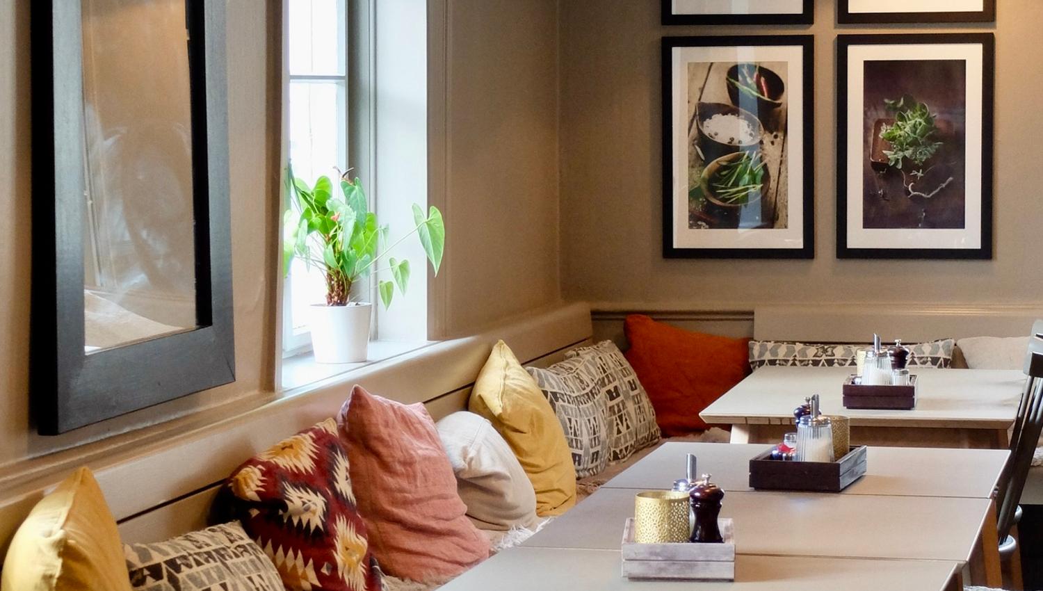 Table and bench with pillows in restaurant