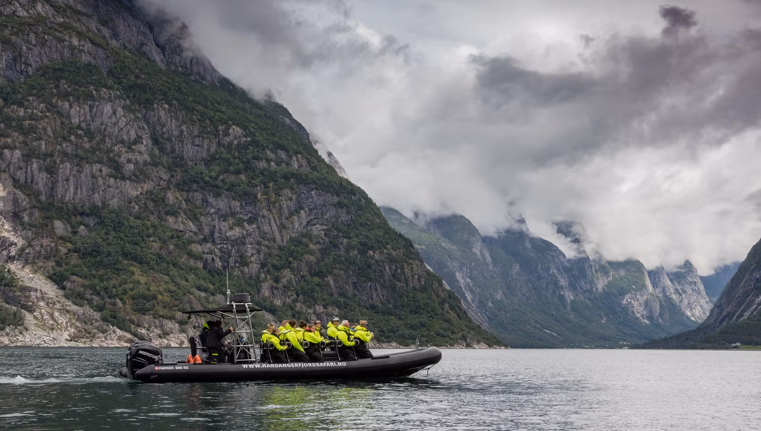 A rib boat on the fjord, filled with passengers.