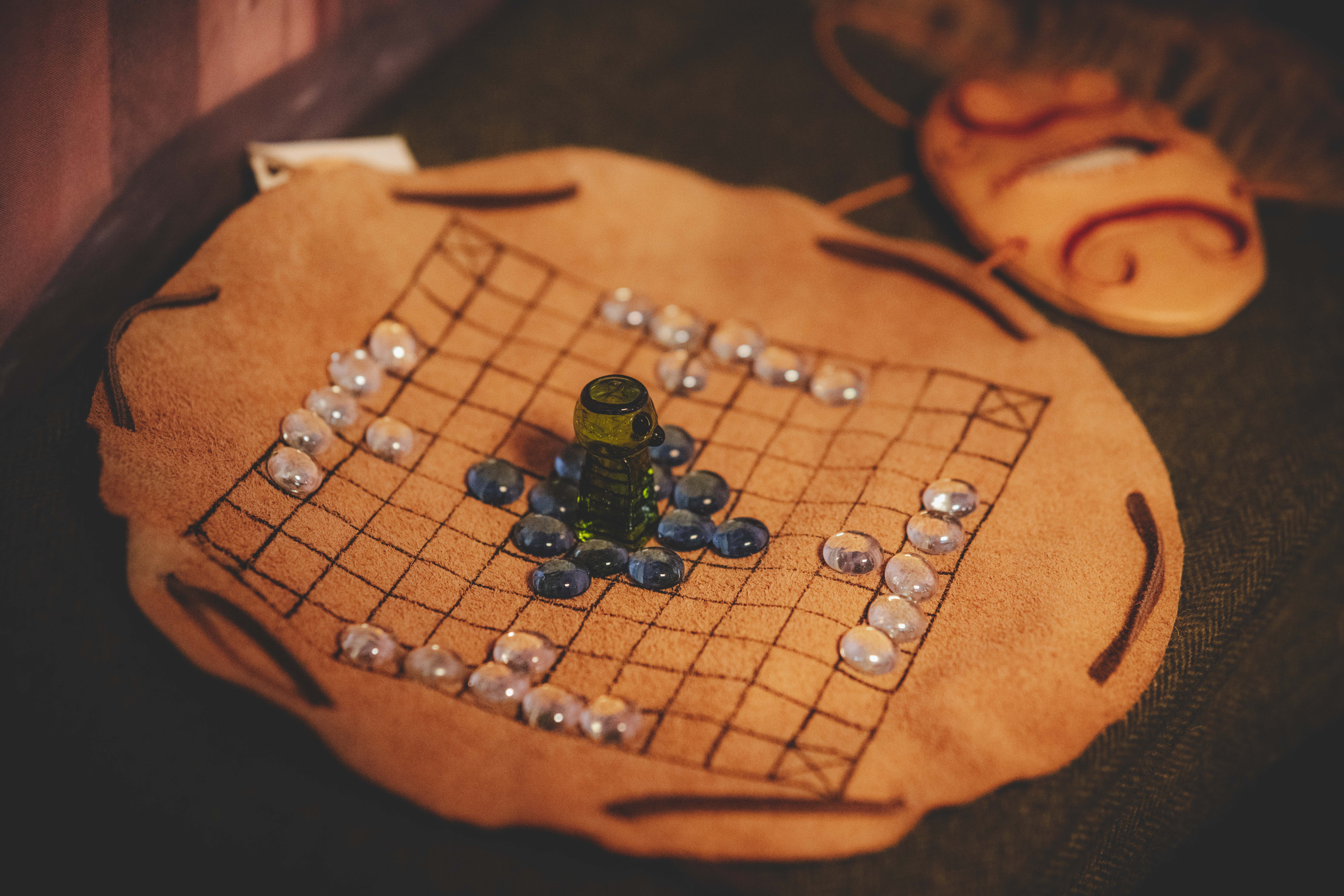 Ein Wikinger-Brettspiel, bestehend aus einem Lederstoff als Spielbrett und marmorähnlichen Steinen als Spielfiguren.