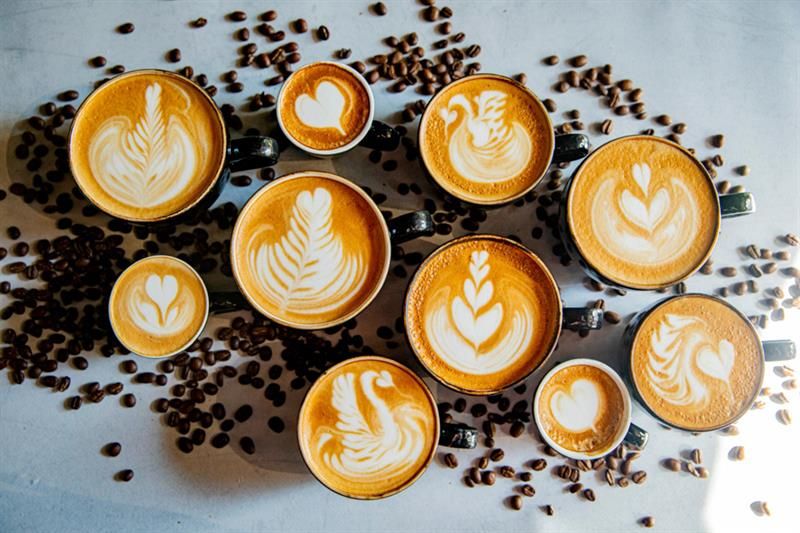Detail of various cups filled with cappuccino.