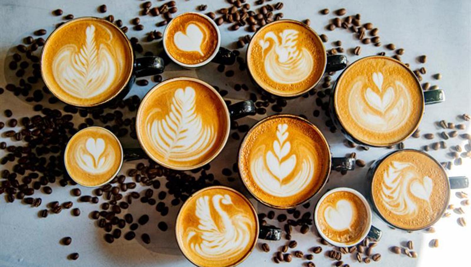 Detail of various cups filled with cappuccino.