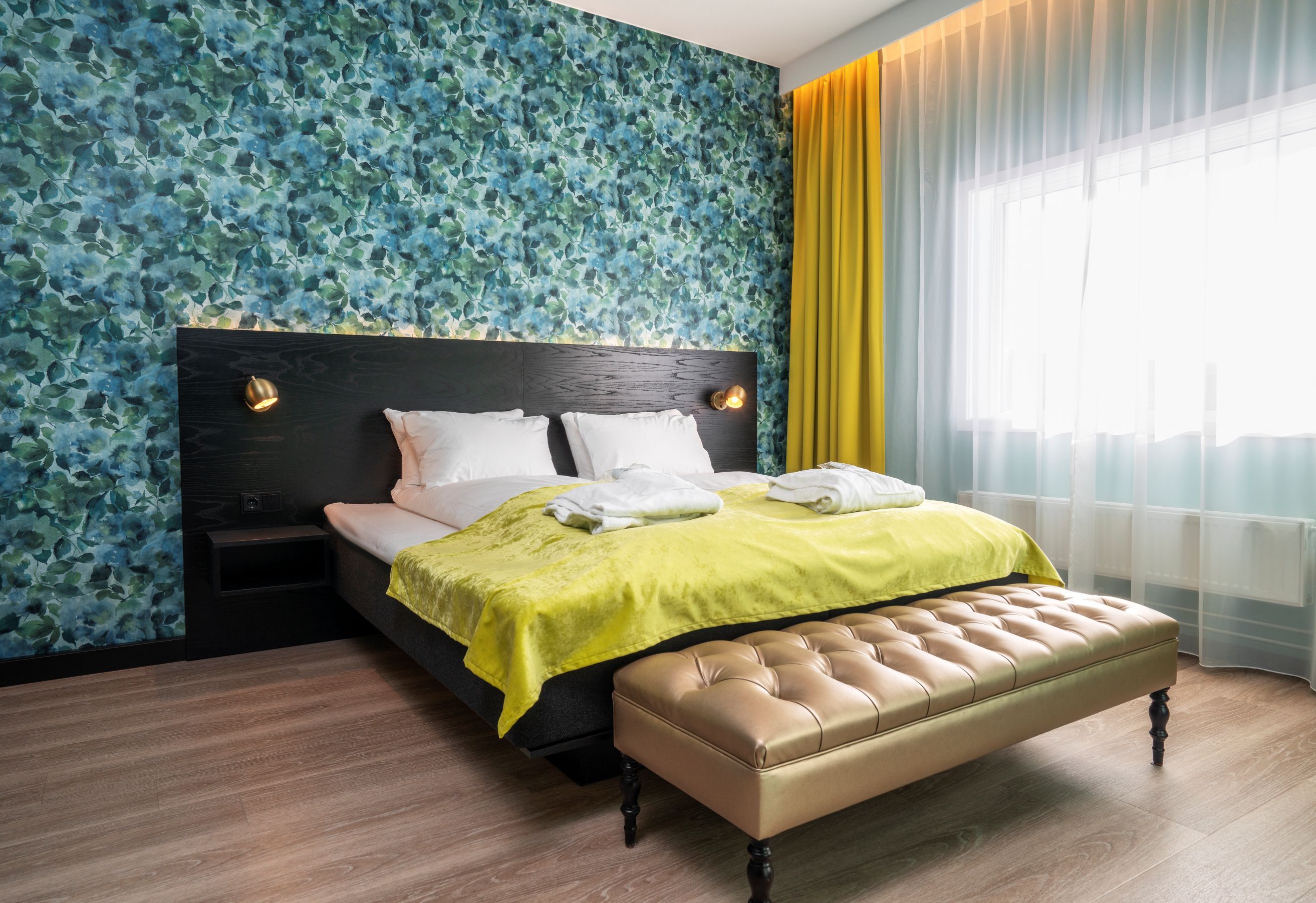 Hotellrom med dobbeltseng og mønstret tapet på veggen