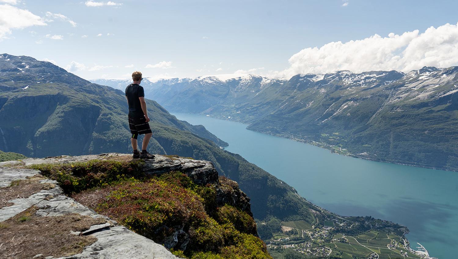 Tourist enjoying splendid views from Dronningstien in Hardanger.