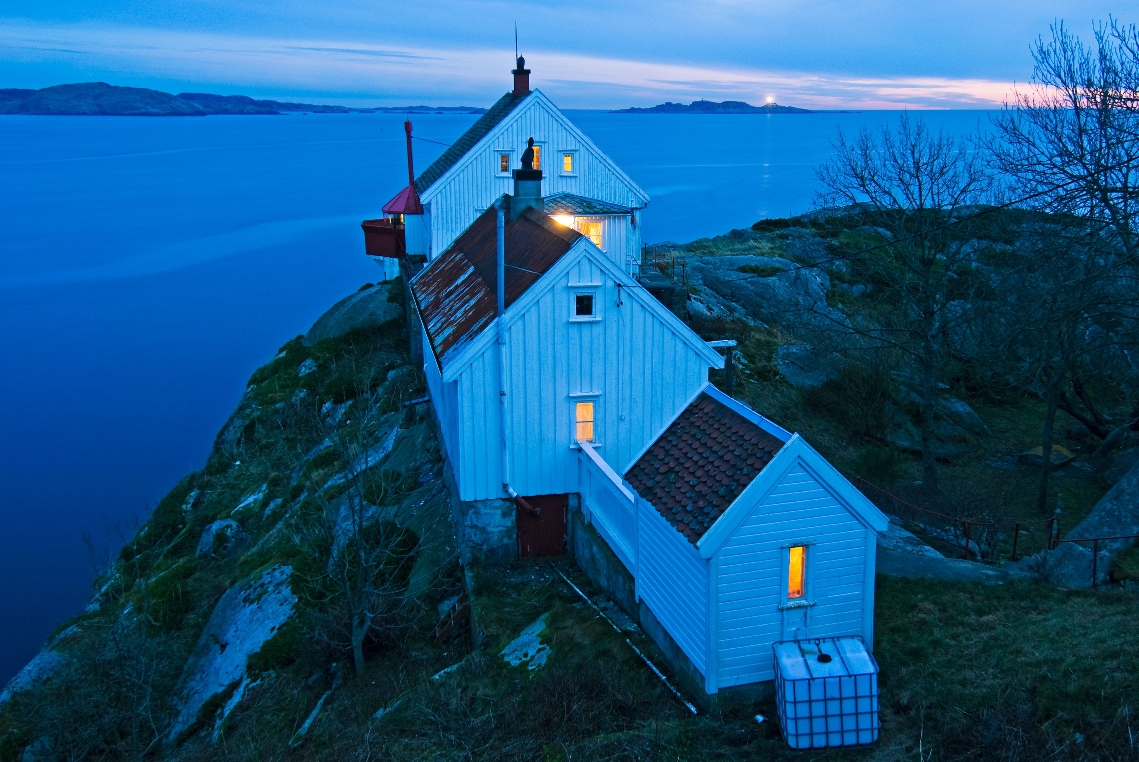 Huset på Hatholmen fyr, med fyret bak og utsikt ut mot havet