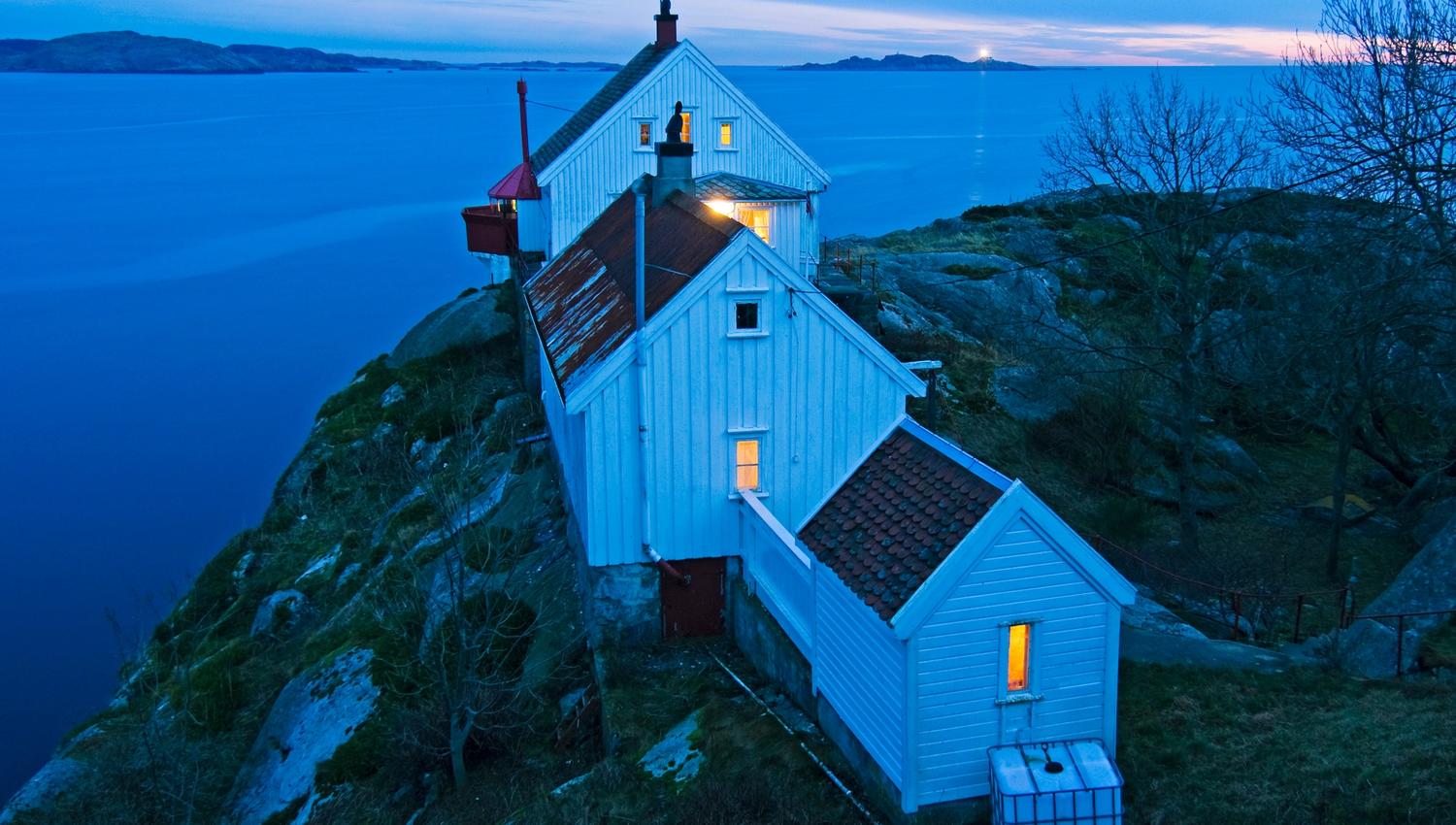 Huset på Hatholmen fyr, med fyret bak og utsikt ut mot havet