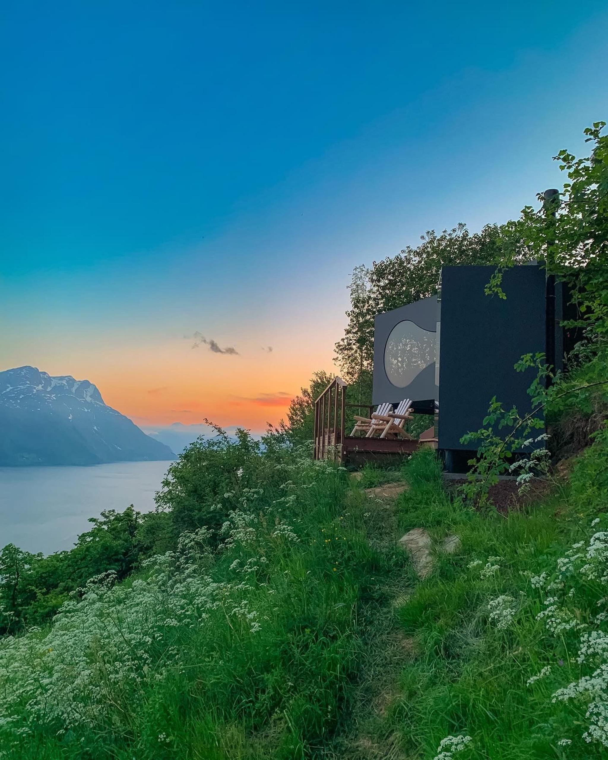 Stunning panoramic view from the Birdbox cabin at Skaara Living on Lotsberg in Nordfjord, surrounded by mountains and fjord landscape.