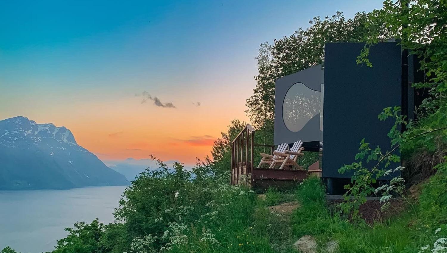 Stunning panoramic view from the Birdbox cabin at Skaara Living on Lotsberg in Nordfjord, surrounded by mountains and fjord landscape.