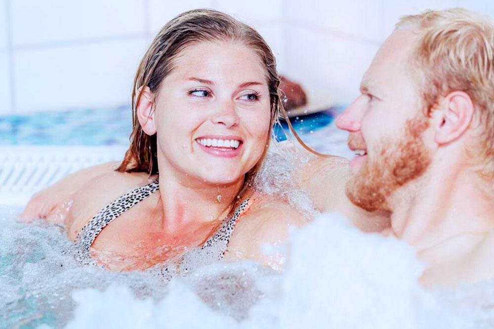mann og dame slapper av i boblebad på Spa og velværeavdeling i Skien fritidspark
