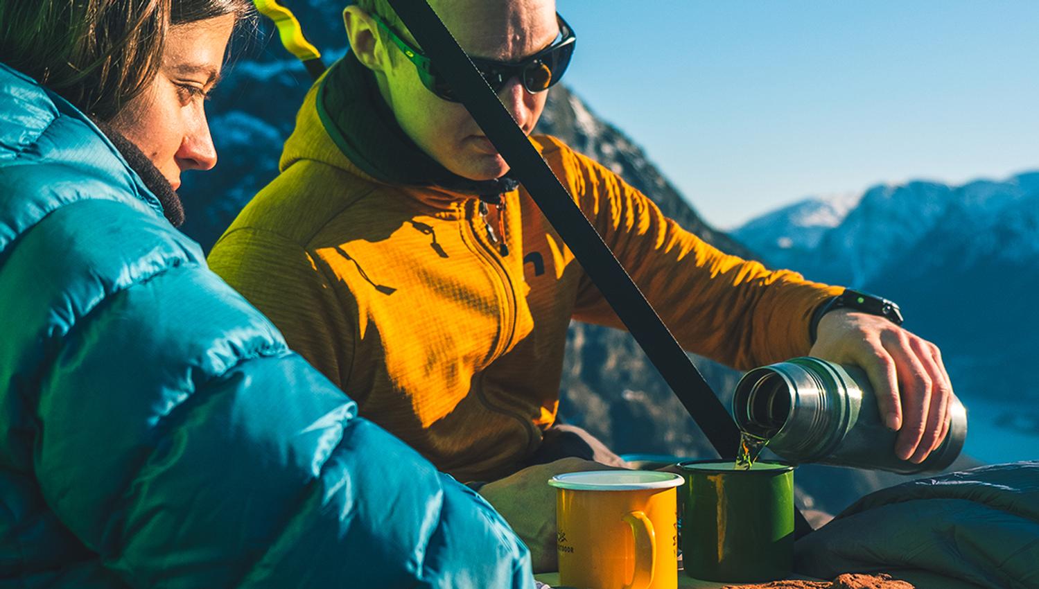 Eit par nyt kaffi og kjeks i solskinet medan dei heng på ein portaledge i fjellveggen over Hardangerfjorden. Uforgløymeleg oppleving i naturen.