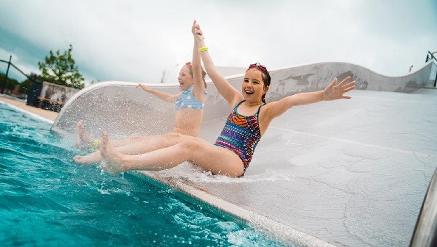 Two girls taking the slide down